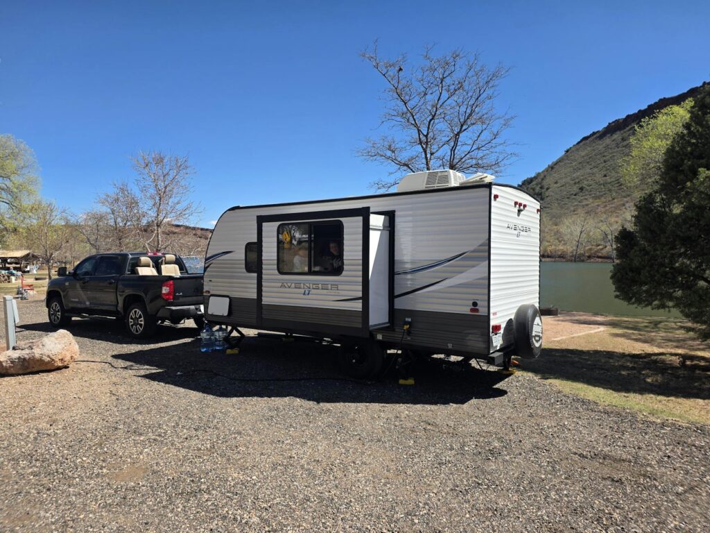 A family preparing their vehicle for a holiday road trip with a trailer attached. — holiday driving safety towing Las Vegas