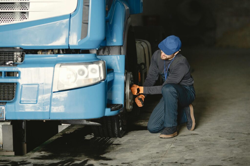 A mechanic performing routine maintenance on a heavy vehicle to prevent breakdowns. — heavy vehicle towing reasons