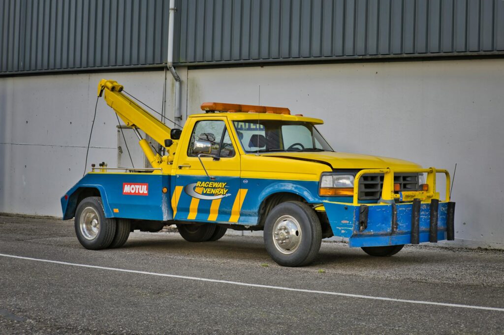Image of a satisfied customer standing next to a tow truck, highlighting affordable towing services Las Vegas
