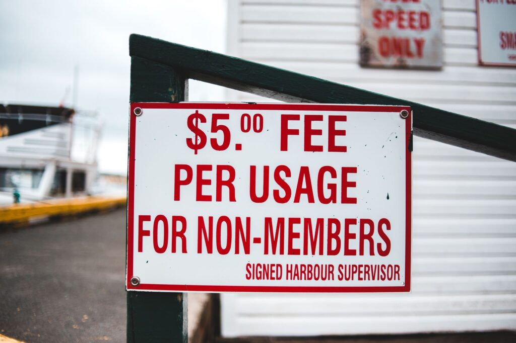 A close-up of towing fees and regulations posted in a parking area — why cars get towed