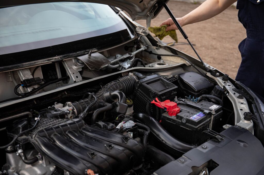 A mechanic replacing a car battery in a garage setting. — dead battery assistance